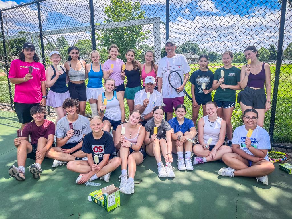 Roosevelt graduate Greg Wicklund poses with boys and girls tennis players at Lake Hiawatha during Teddy Tennis Camp