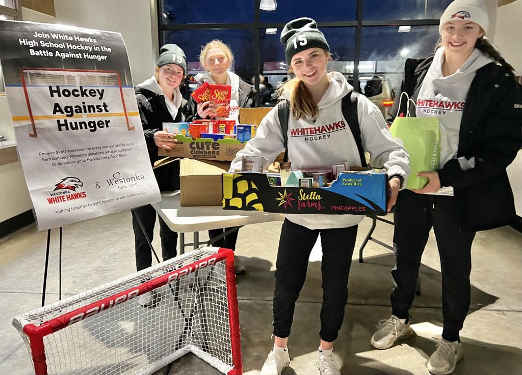 hockey players with food shelf donations