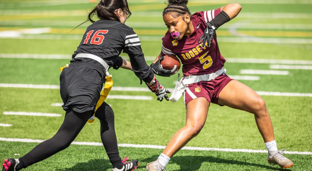 Image of the Minneapolis Roosevelt Girls flag football running back spinning to avoid her opponent