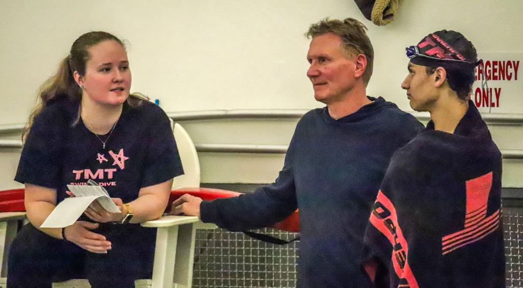 Image of the Minneapolis TMT Swimm team coaches in discussion during a swim meet